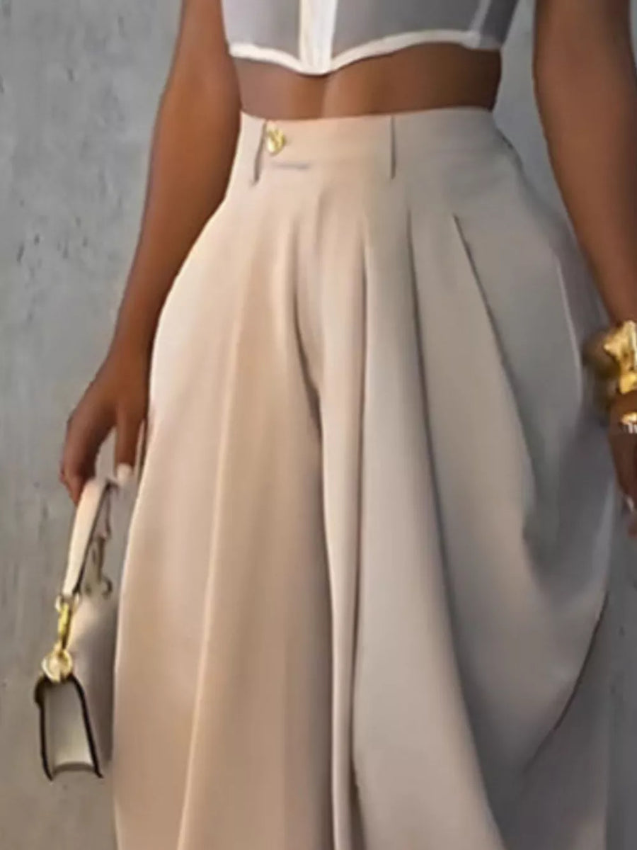 Light khaki sculptural pleated high-waisted pants with button detail.