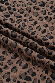 Brown jacquard shirt with black leopard print texture, half-zip neckline detail.