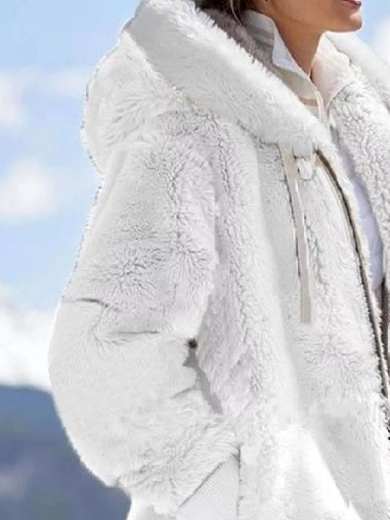 White fuzzy zip-up hoodie with drawstring and pockets, soft fleece outerwear.