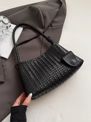 Black woven shoulder bag with braided strap and flap closure