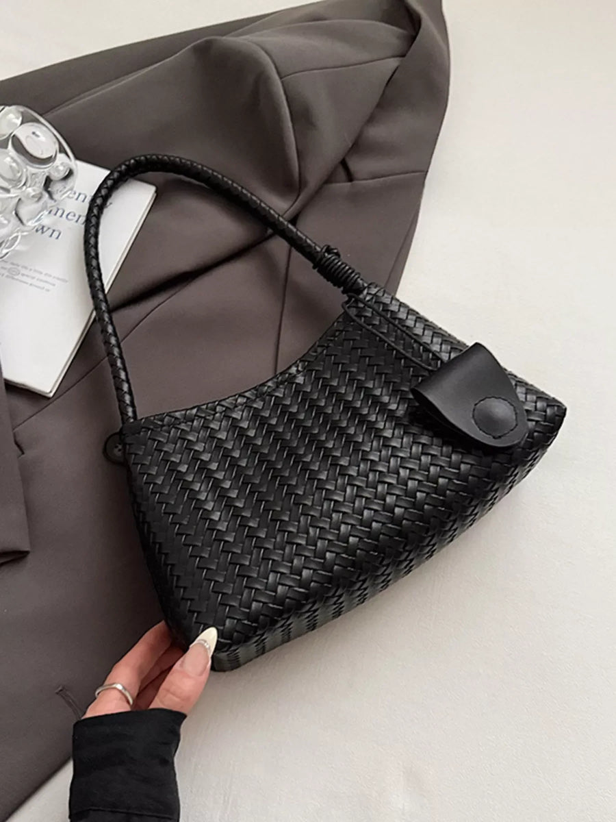 Black woven shoulder bag with braided strap and flap closure