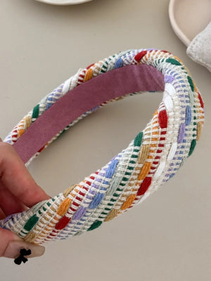 Woven plaid padded headband with colorful woven accents and a pink lining.