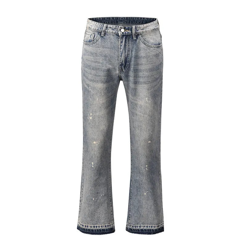 Distressed wash bootcut jeans with raw hem in medium blue denim, featuring paint splatters and a frayed hem.