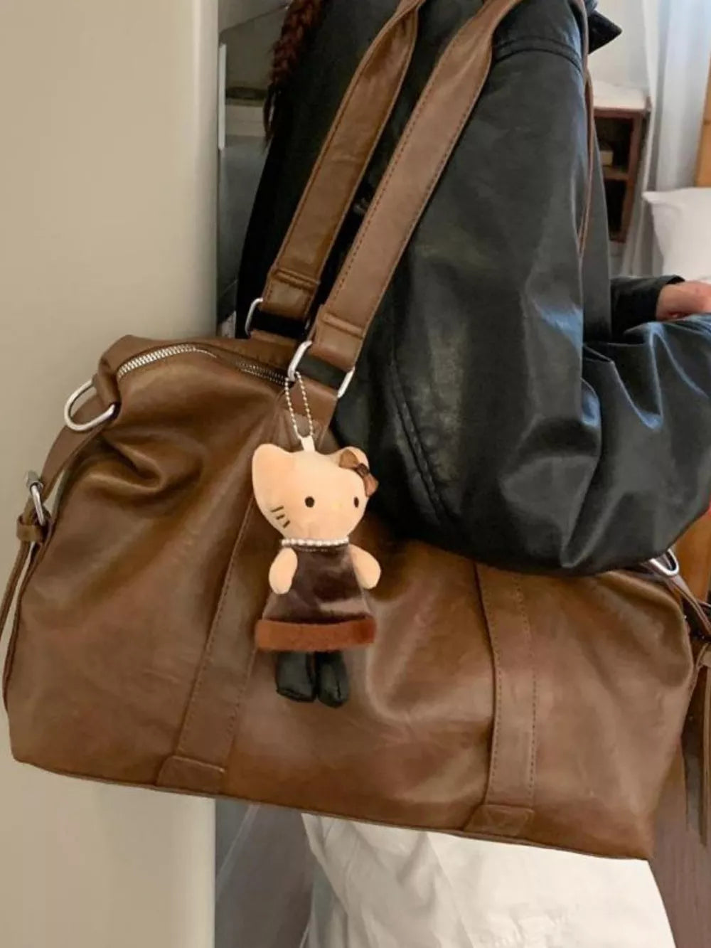 Large brown pu leather shoulder bag with a plush cat charm and double straps.