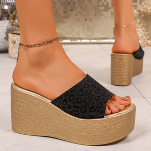 Black leopard print platform sandals with gold wedge heel.