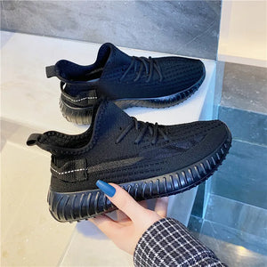 Black textured knit platform sneakers with white stitching detail on heel tab.