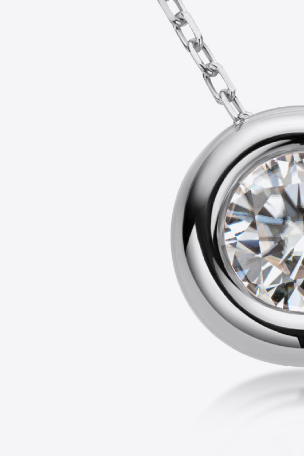 Silver solitaire necklace with bezel-set moissanite and delicate chain.