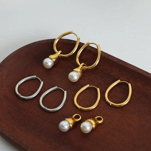 Pearl drop oval hoop earrings in gold and silver with white pearl accents.