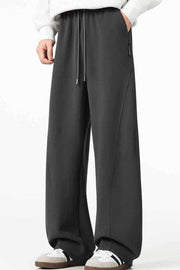 Men's black relaxed wide-leg sweatpants with drawstring and side seams.