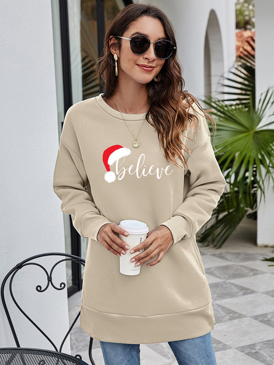 Beige Christmas graphic tunic sweatshirt with Santa hat and "Believe" text, crewneck, long sleeves.