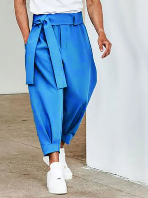Blue balloon-leg wrap trousers with a tie belt and cuffed ankles.