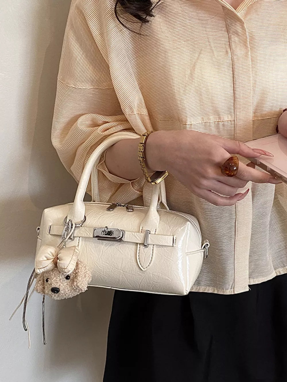 Ivory handbag featuring top handle and geometric