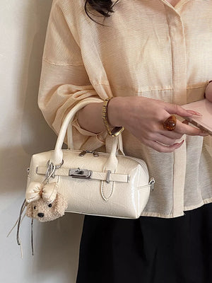 Ivory handbag featuring top handle and geometric