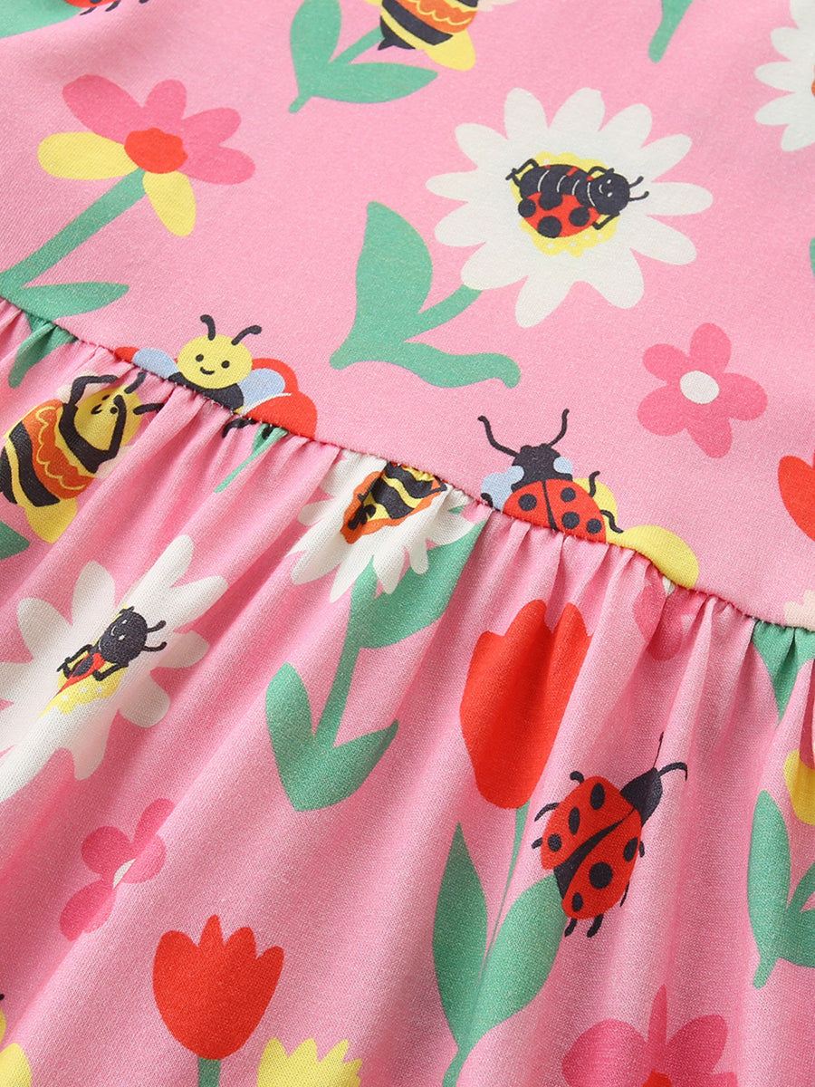 Pink cotton toddler dress with floral and insect print, featuring a ruffled hem.