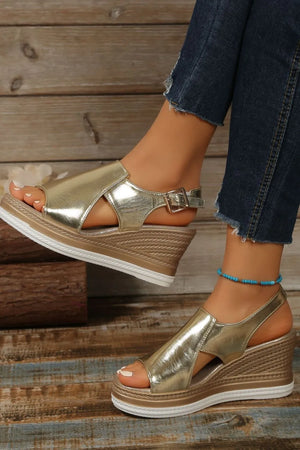 Gold metallic wedge sandals with crisscross detail and buckle closure.