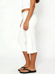 White flared hem capri pants with button detail and eyelets at the waist.