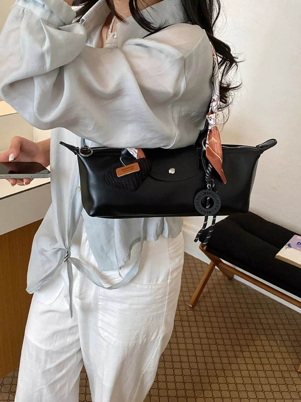 shoulder bag in black featuring front flap and boxy fit