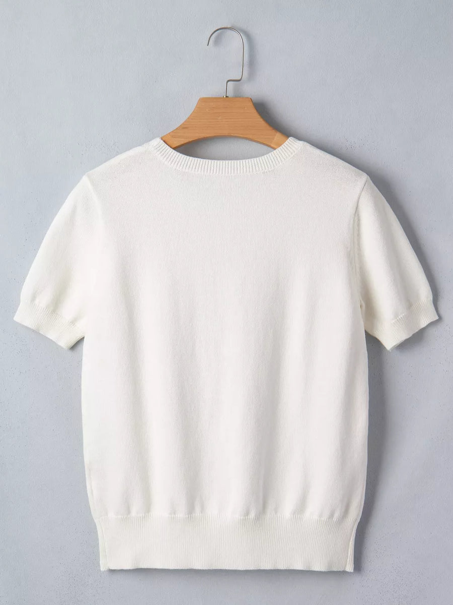 White short-sleeve sweater with crew neck and ribbed hem, made of cotton blend.