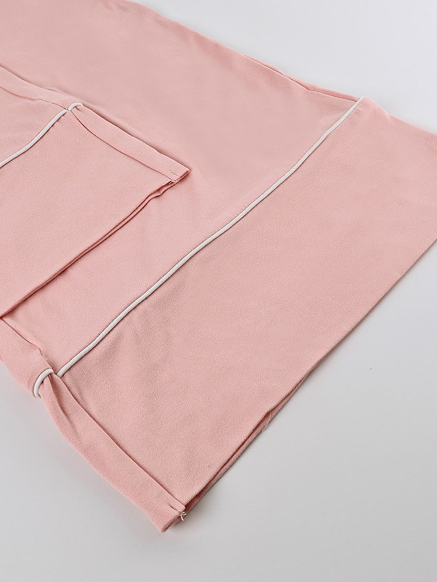 Pink loungewear set with white piping and a pocket detail.