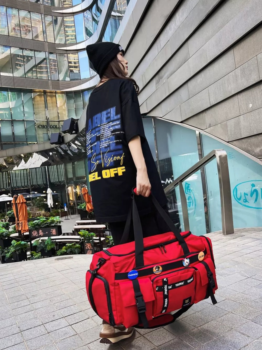 Red duffel bag with multiple pockets and straps, perfect for gym or travel.