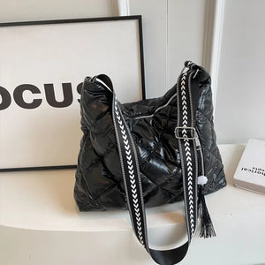 Black diamond quilt padded shoulder bag with patterned strap and tassel detail.