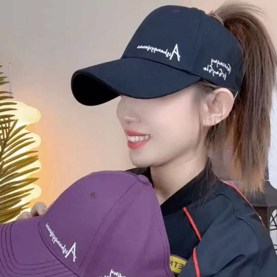 Baseball cap in navy blue with white embroidered logo and text, and a purple cap with matching embroidery.