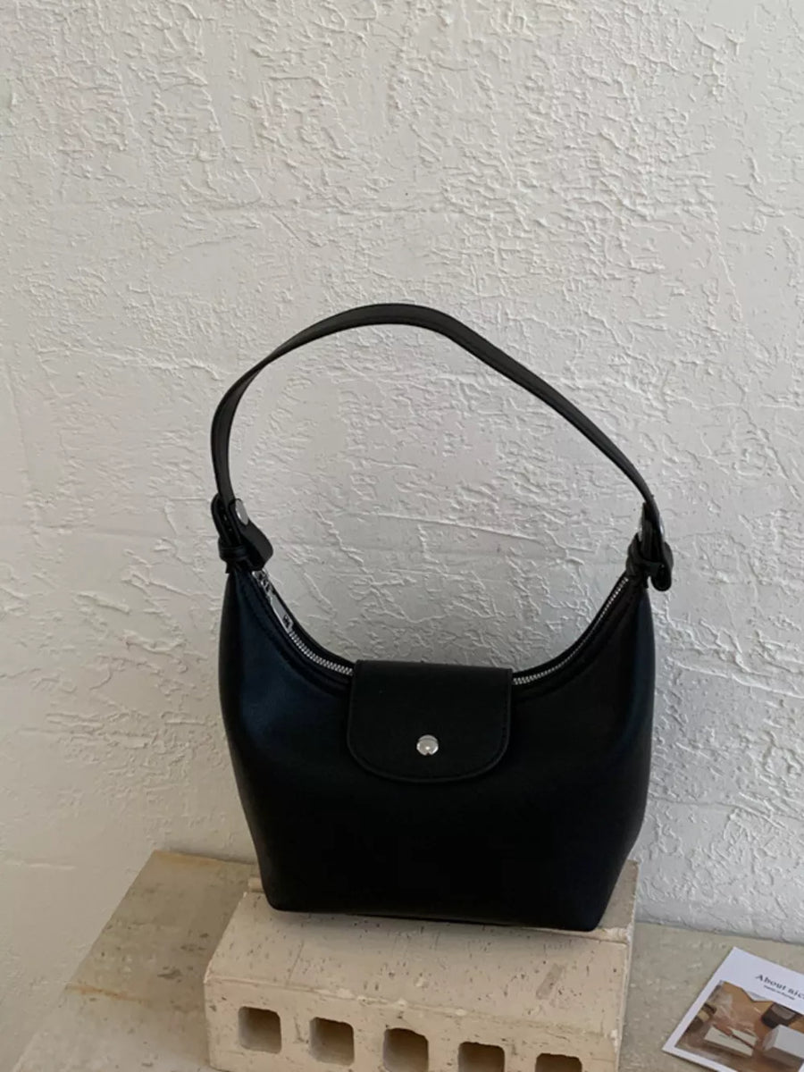 Black crescent hobo bag with silver hardware and snap closure.