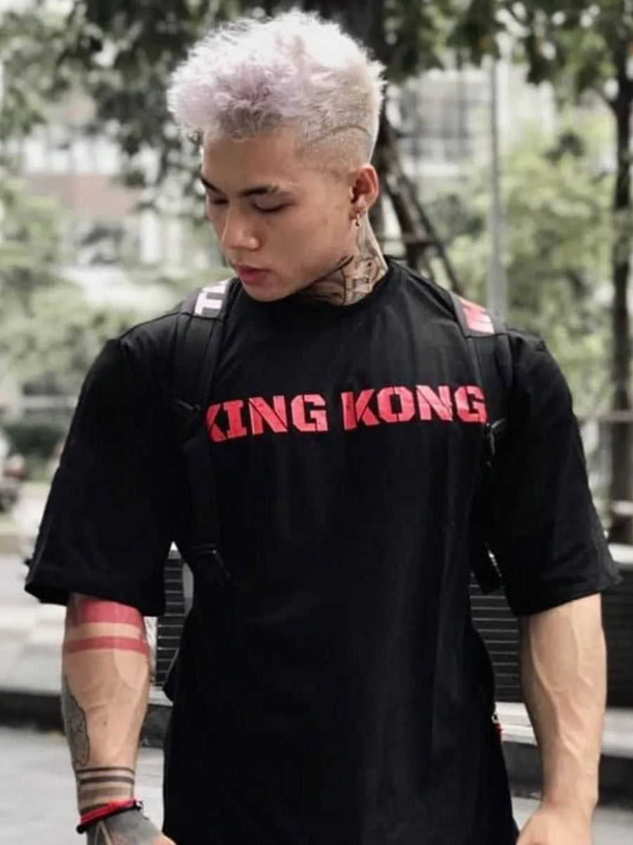 Black oversized graphic tee with red King Kong text, crewneck, short sleeves.