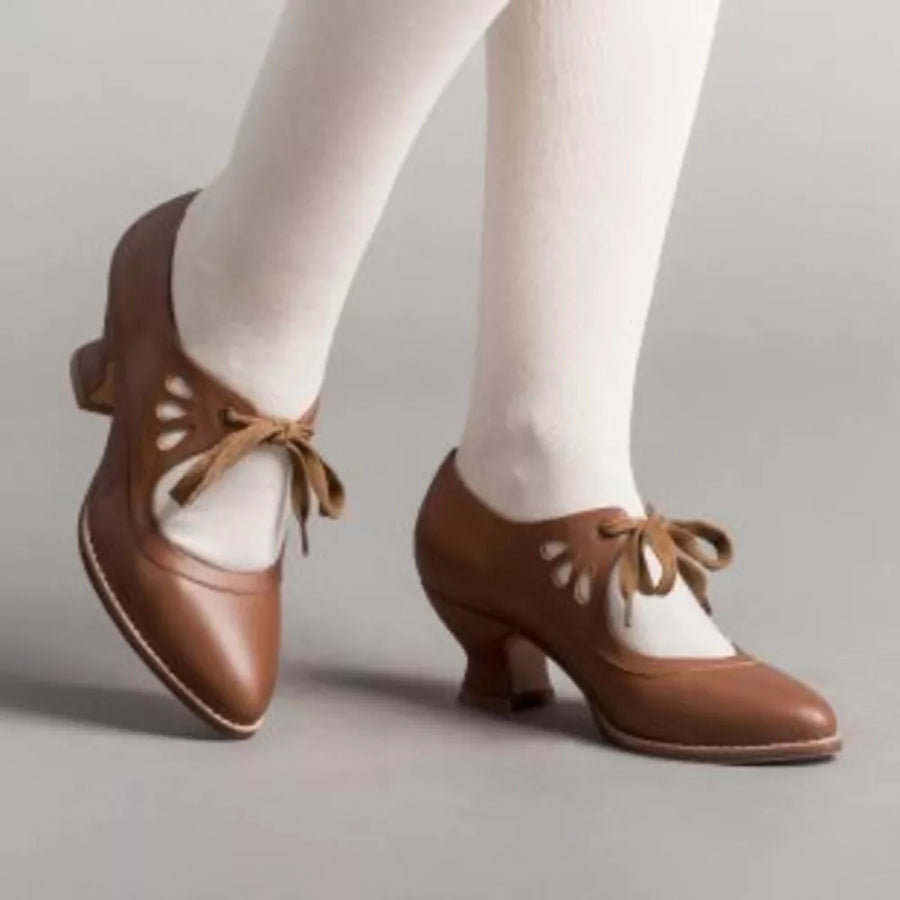 Brown leather Mary Jane heels with cutouts and bow detail
