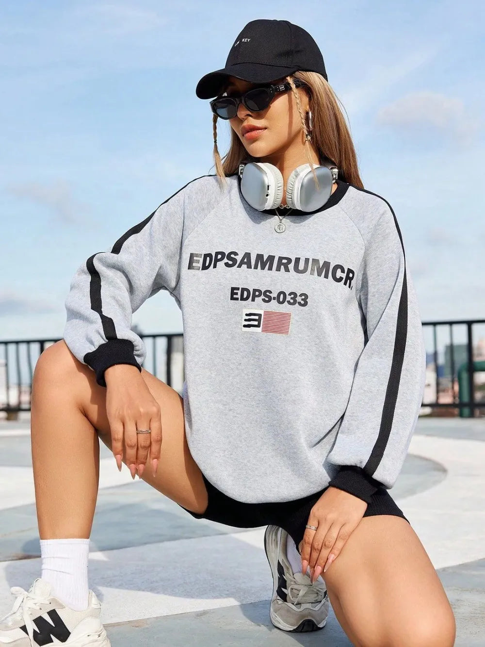 Light gray graphic sweatshirt with varsity stripes on sleeves and black trim.