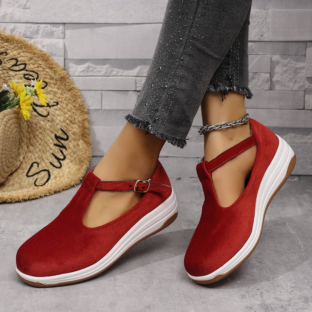 Red T-bar flat slip-ons with adjustable strap and white sole.