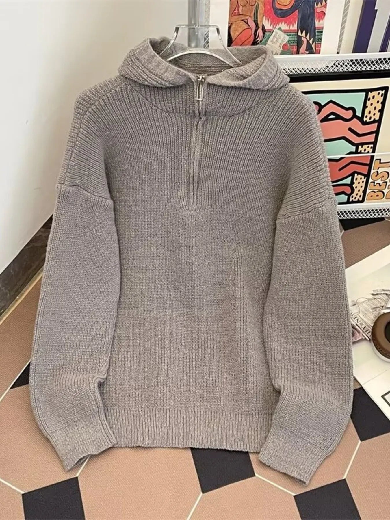 Gray knit hoodie with half-zip neckline and ribbed details.