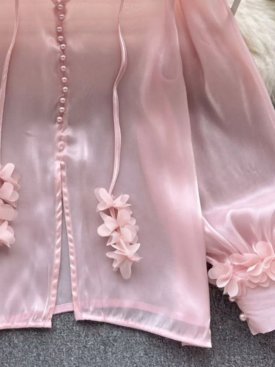 Pink sheer organza button-down shirt with delicate floral appliqué and pearl details.