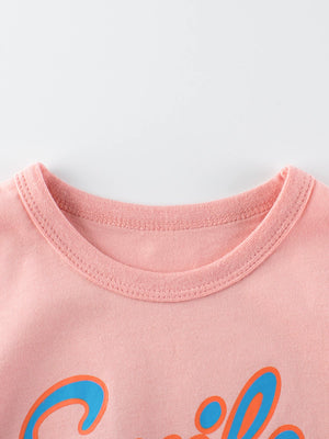 Pink crewneck t-shirt with blue and orange graphic print and contrast stitching.