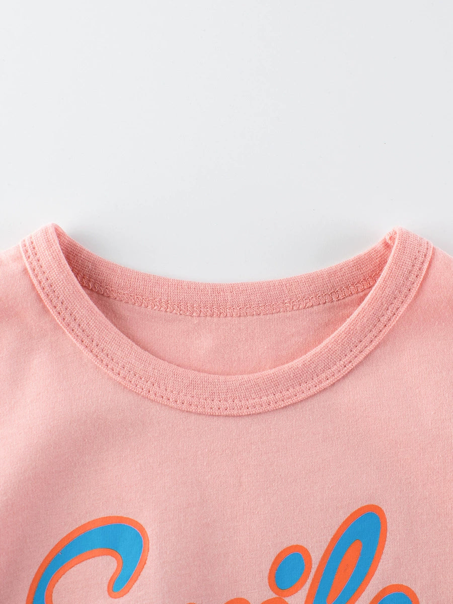 Pink crewneck t-shirt with blue and orange graphic print and contrast stitching.