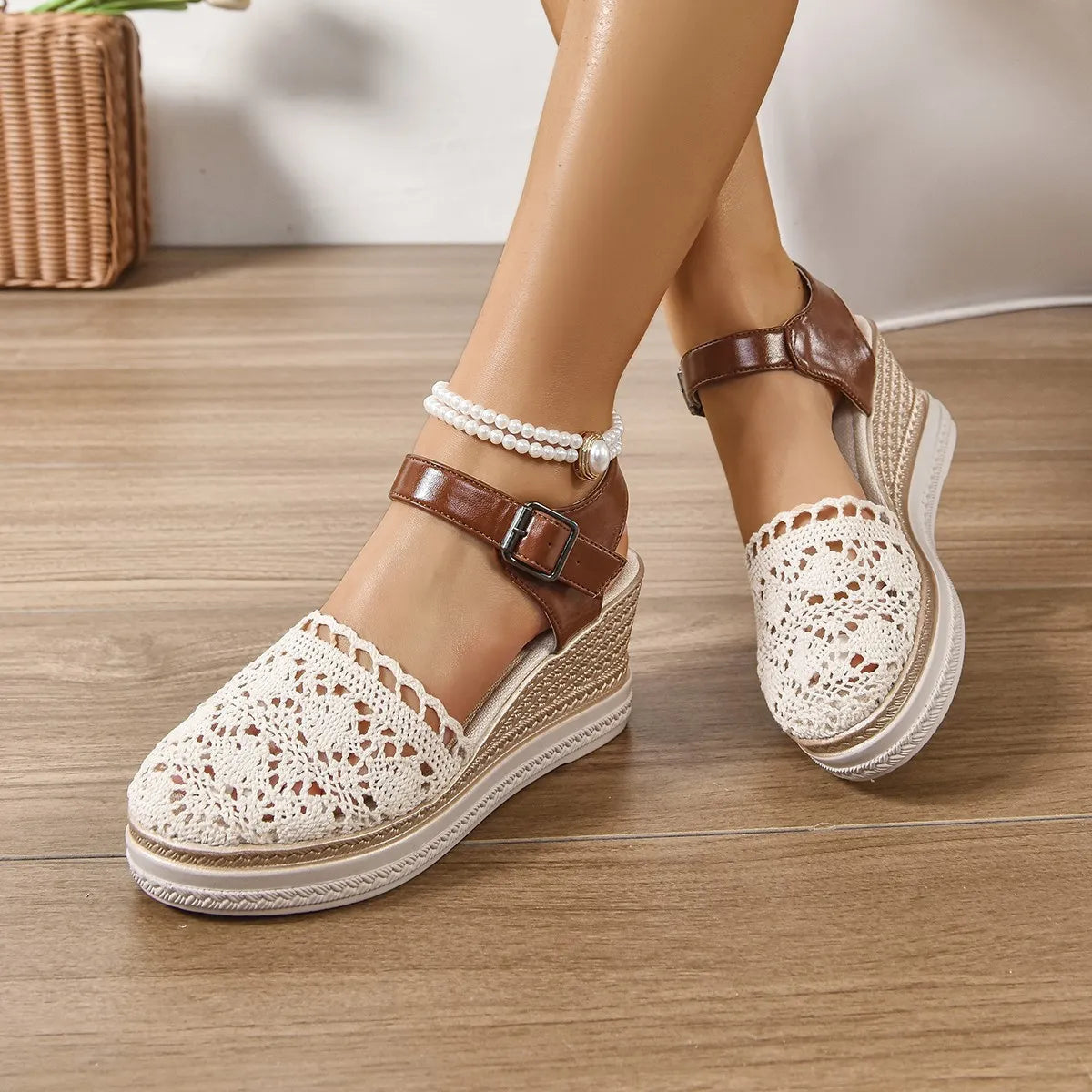 Beige crochet and leather wedge ankle strap sandals with buckle closure and pearl anklet.