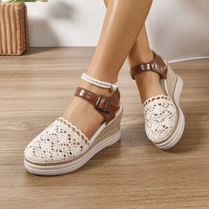 Beige crochet and leather wedge ankle strap sandals with buckle closure and pearl anklet.