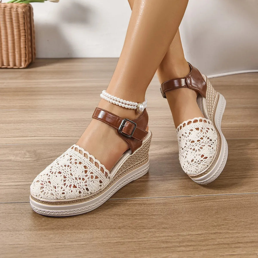 Beige crochet and leather wedge ankle strap sandals with buckle closure and pearl anklet.