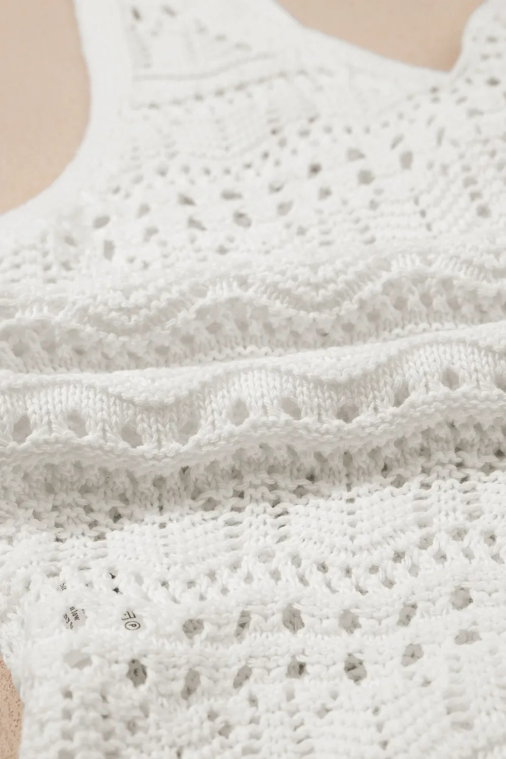 White crochet tank top with ruched front detail and open knit pattern.
