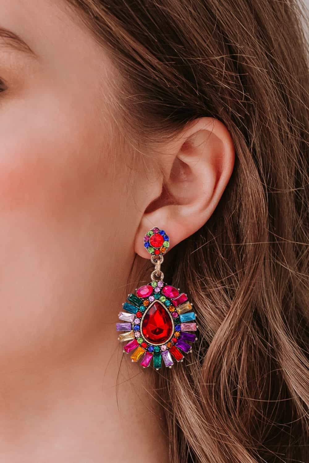 Multicolor dangle earrings with a large red teardrop gem and surrounding colorful baguette gems.
