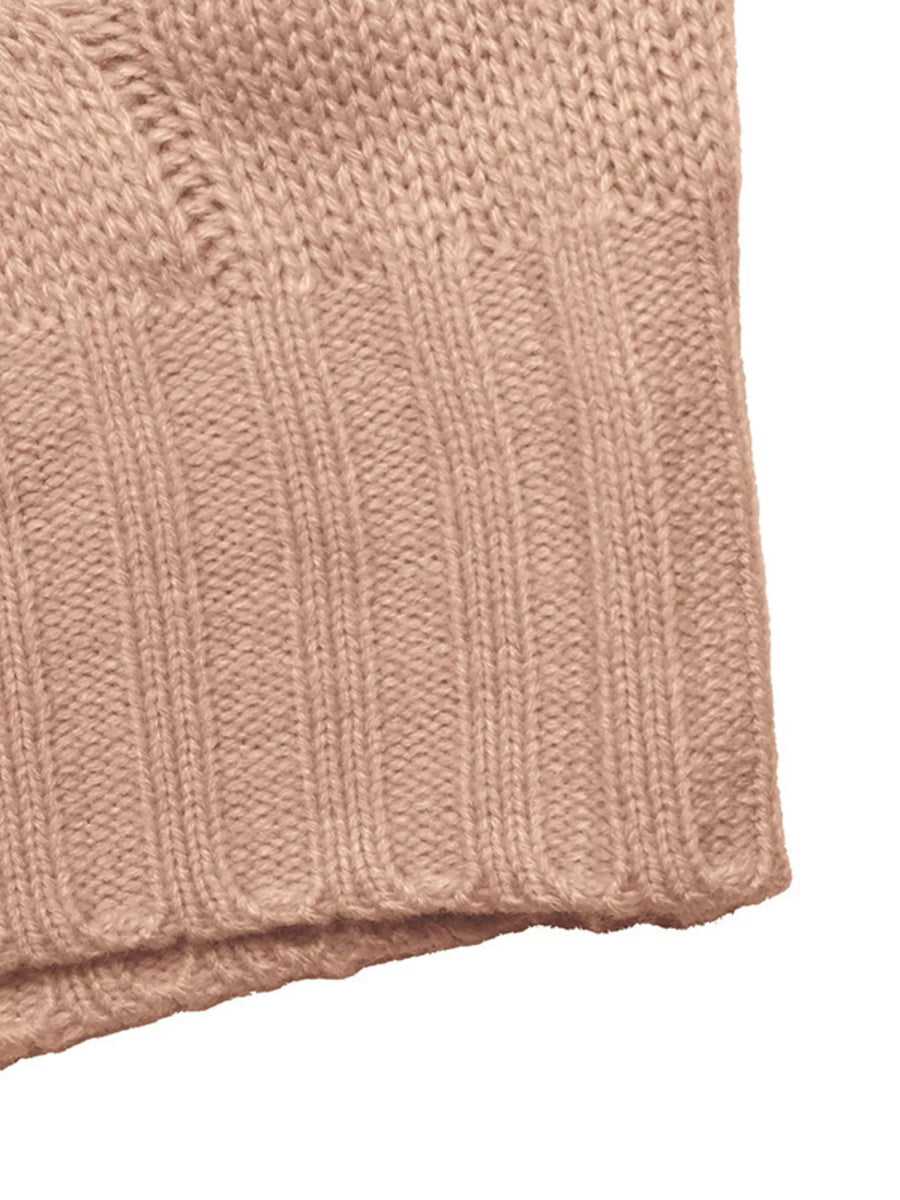 Pink cable knit sweater vest detail, ribbed hem and acrylic fabric texture.