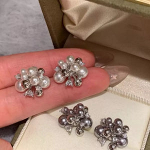 Elegant pearl cluster earrings with zircon accents in white and light gray.