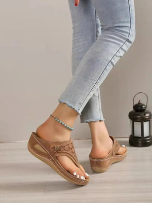 Camel laser-cut thong sandals with adjustable strap and cushioned sole.