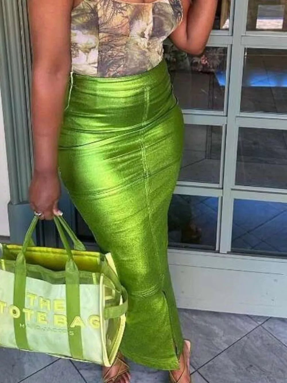 Glistening lime green high-waisted maxi skirt with a bodycon fit and side slit.