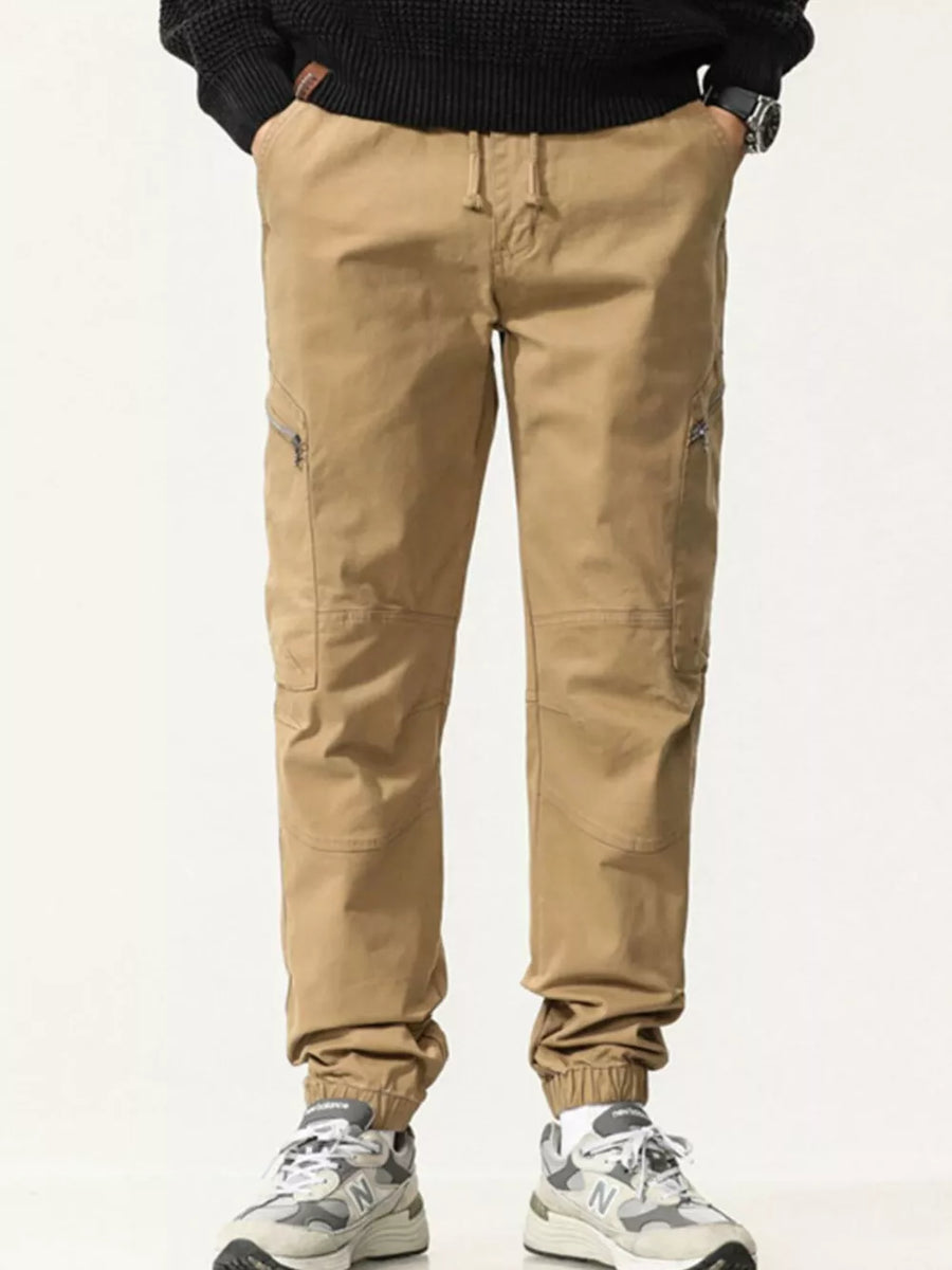 Men's Khaki cotton cargo pants with zippered pockets and drawstring waist.