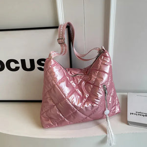 Pink diamond quilt padded shoulder bag with tassel detail and adjustable strap.