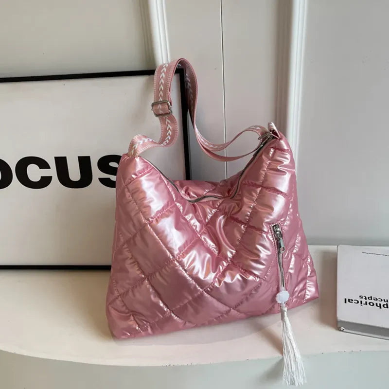 Pink diamond quilt padded shoulder bag with tassel detail and adjustable strap.