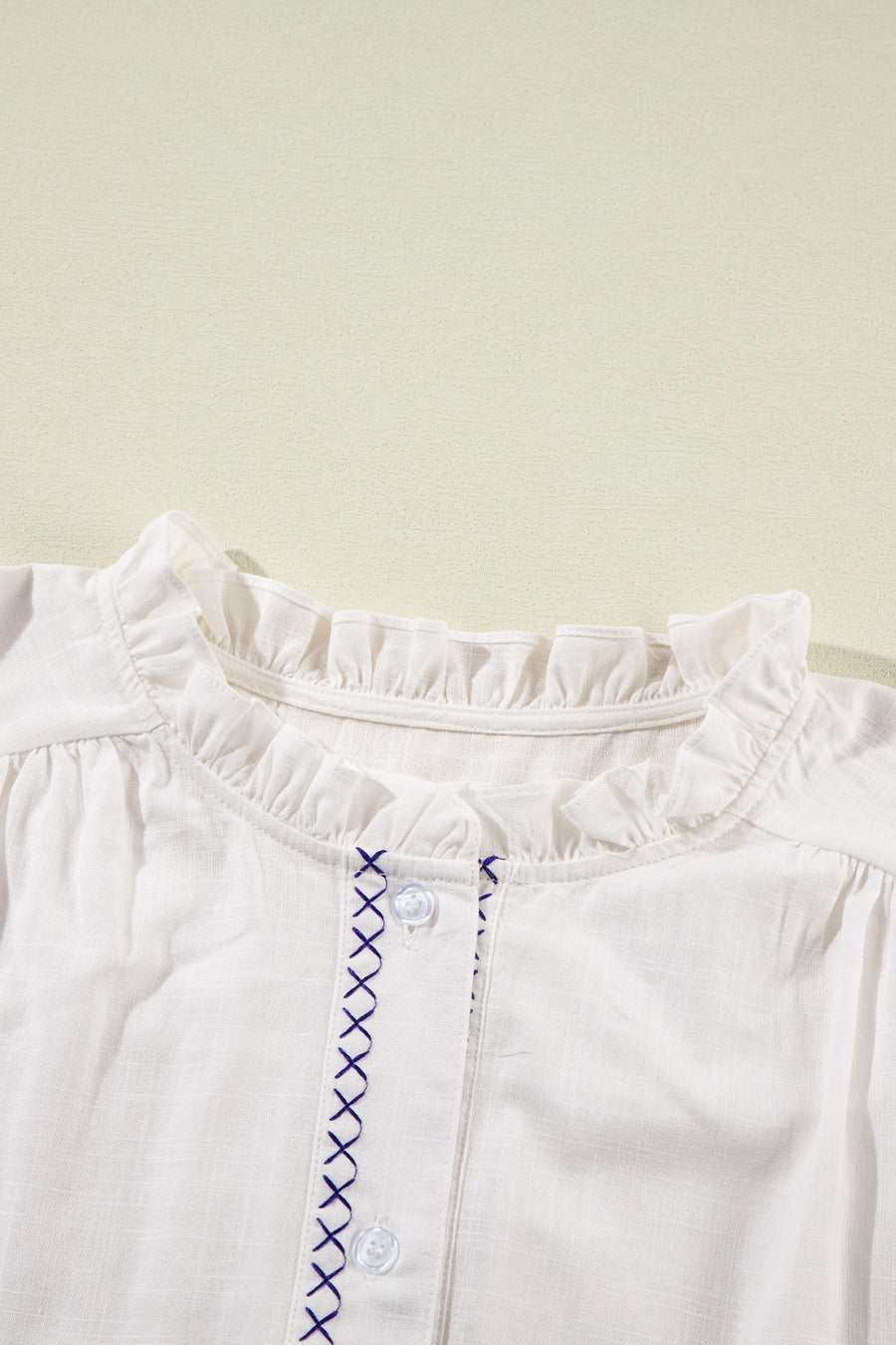 White embroidered blouse with ruffled neckline and button front