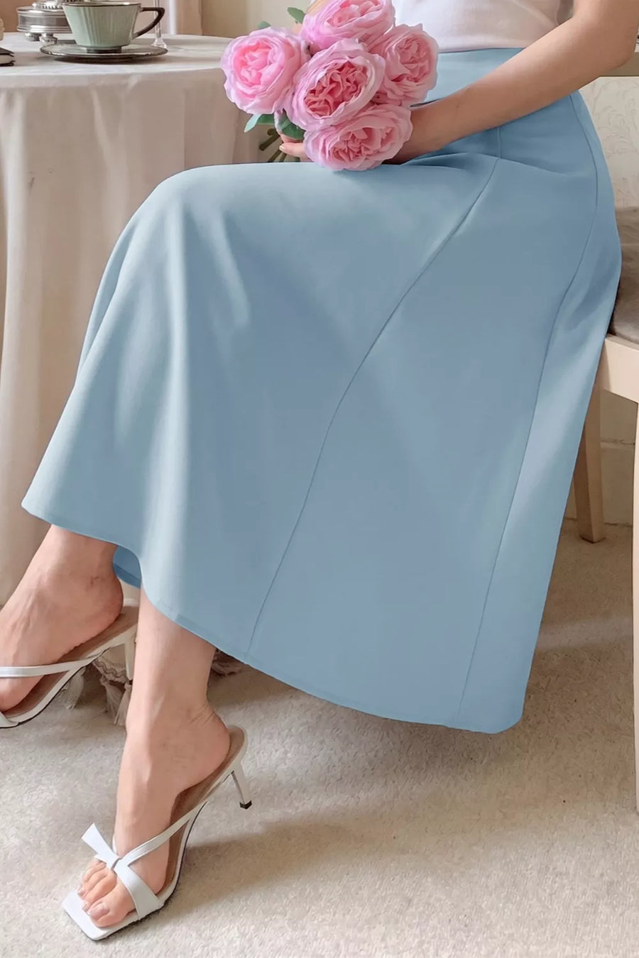 Blue A-line midi skirt with buttons, shown with white heeled sandals.