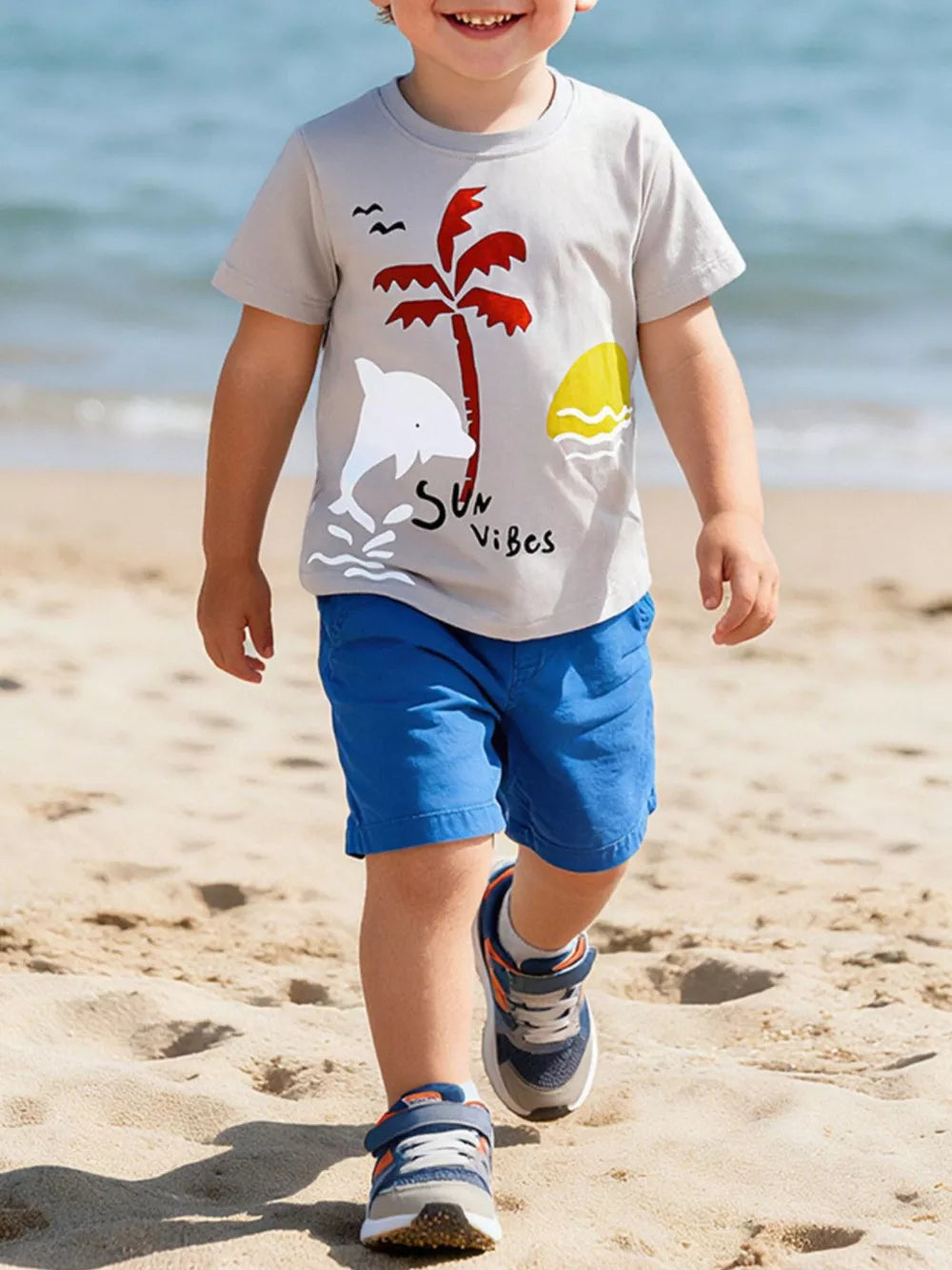 Kids grey cotton t-shirt with dolphin, palm tree, and sun graphic.